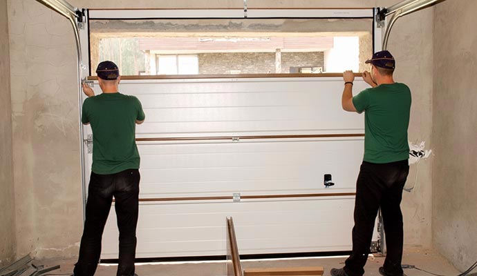Two technicians installing a garage door