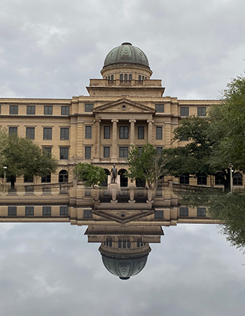Texas A&M Academic Building reflected in a pool in College Station